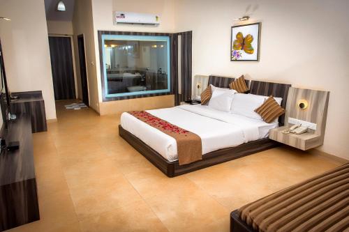 a bedroom with a large white bed in a room at Adamo the Resort in Matheran