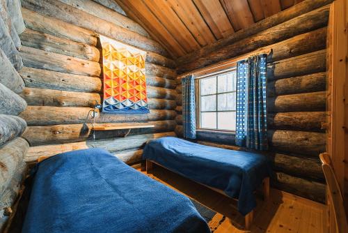 um quarto com duas camas num chalé de madeira em Pikku-Junga em Kuusamo