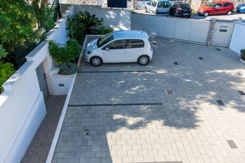 a small white car parked in a parking lot at Apartments Villa Alba in Dubrovnik