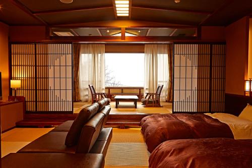 ein Wohnzimmer mit einem Sofa und einem Tisch in der Unterkunft Kaiyu Notonosho in Wajima