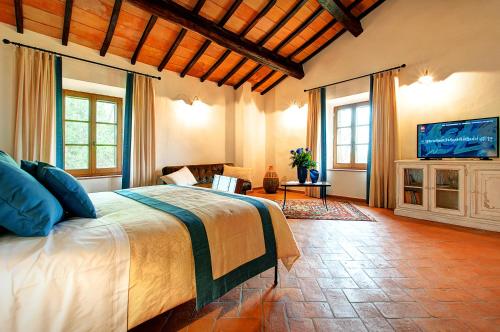 a bedroom with a bed and a flat screen tv at Il Giuncheto in Trequanda