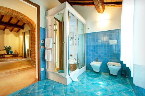 a blue bathroom with a toilet and a shower at Il Giuncheto in Trequanda