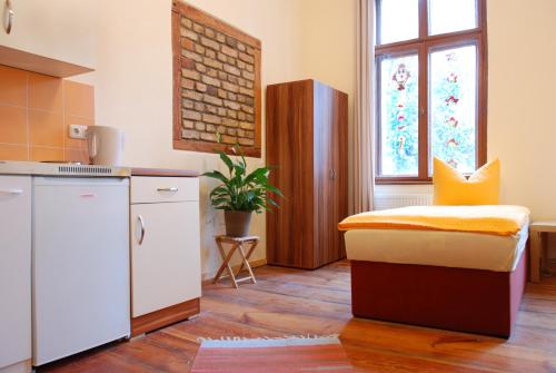eine Küche mit einem Bett in der Mitte eines Zimmers in der Unterkunft Altstadt-Pension-Potsdam in Potsdam