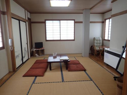 a living room with a coffee table and red pillows at Seisenso in Nozawa Onsen