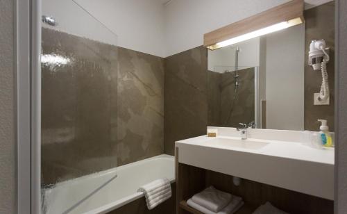 y baño con lavabo, ducha y bañera. en Hôtel-Restaurant de La Paix, en Saint-Palais