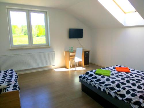 a bedroom with a bed and a desk and a window at Chill Out Wygryny in Ruciane-Nida