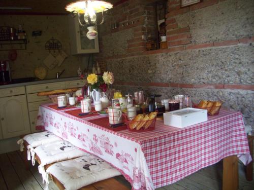 una mesa con un mantel rojo y blanco y cestas de comida en Le Clos de Saint Amour, en Montauban