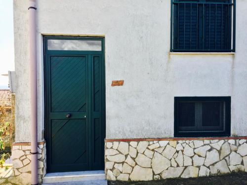 una puerta verde al lado de un edificio en Casa Spilla, en Caltanissetta