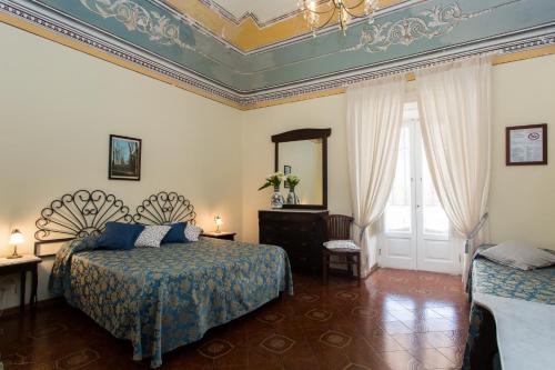 una camera d'albergo con due letti e uno specchio di Hotel Poseidon a Città di Lipari