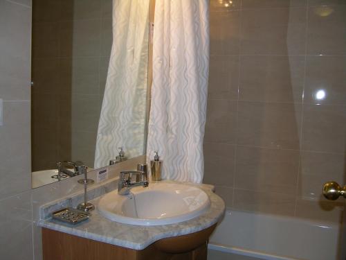 a bathroom with a sink and a shower curtain at Albatros Playa 3 - 1307 in Mar de Cristal