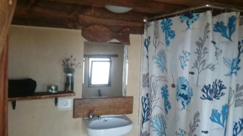 a bathroom with a sink and a shower curtain at Caravan Apartment in Tinajo