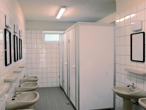 a bathroom with a row of sinks and toilets at Dávodi Camping és Szabadidőpark in Dávod