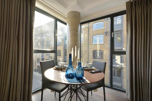 a dining room table with chairs and a large window at Twyne House Apartments in London