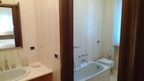 a bathroom with a tub and a sink and a toilet at Villa le Noci in Bettola