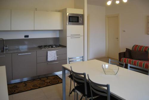 a kitchen and living room with a table and a couch at Residence La Margherita in Lazise