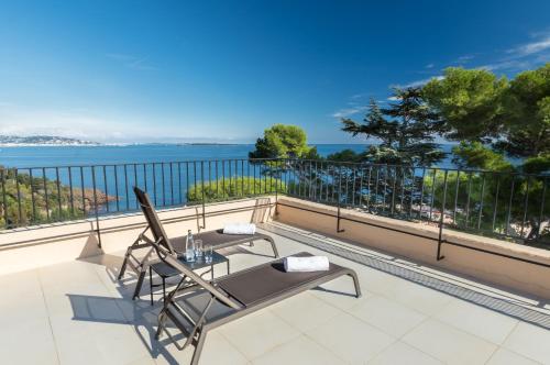 a patio with a table and chairs on a balcony at Hôtel Club Port La Galère in Théoule-sur-Mer