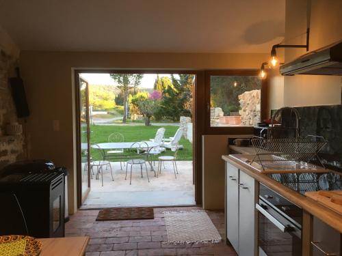 Il comprend une cuisine avec une terrasse dotée d'une table et de chaises. dans l'établissement Gites 