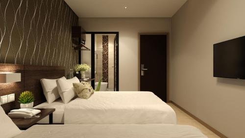 a bedroom with a bed and a flat screen tv at The Square Hotel in Skudai
