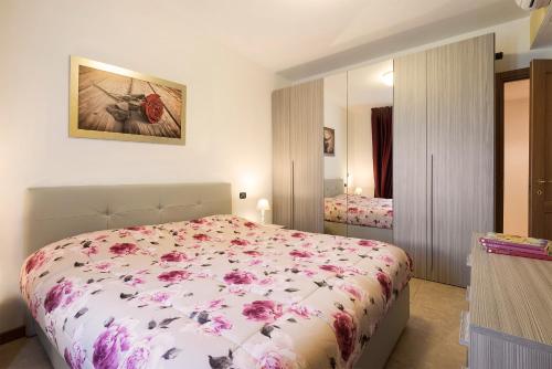 ノヴァーラにあるAirone Apartmentのベッドルーム1室(ピンクの花が咲くベッド1台付)