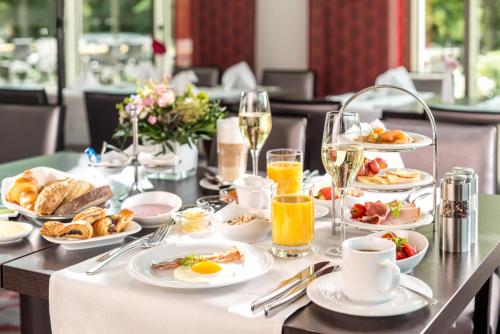a table with plates of food and glasses of champagne at Dorint Hotel Potsdam in Potsdam