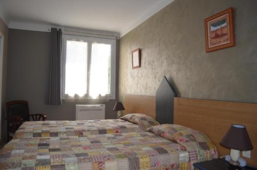 a bedroom with a bed and a window at Hotel Regina in Sète