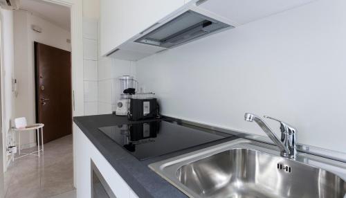 eine Küche mit einer Spüle und einer Mikrowelle in der Unterkunft Italianway-Argonne in Mailand