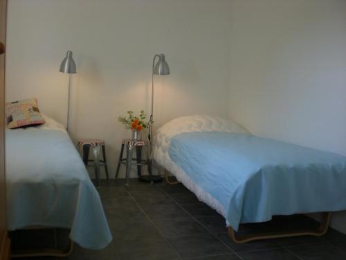 Borrby的住宿－Ola-Nils Gård，一间卧室设有两张床,墙上有两盏灯。
