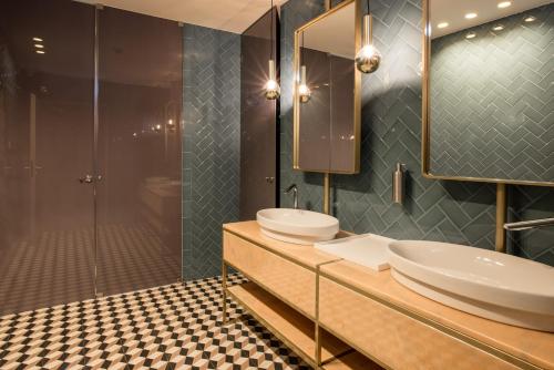 uma casa de banho com 2 lavatórios e um chuveiro em Exe Almada Porto no Porto