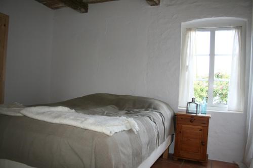 a white bedroom with a bed and a window at Ola-Nils Gård in Borrby