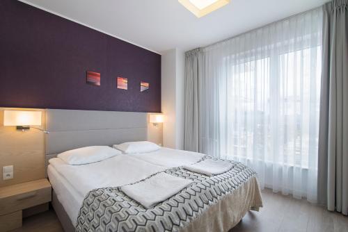 a bedroom with a bed and a large window at Apartament 65 Przy plazy in Władysławowo