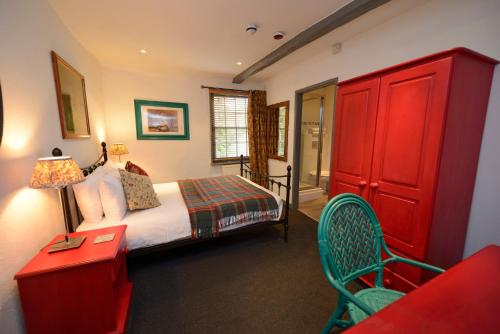 a bedroom with a bed and a red cabinet at The White Lion Inn in Hampton in Arden