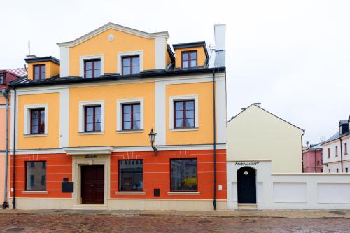 a yellow and orange building on a street at Apartamenty Łozówka in Zamość