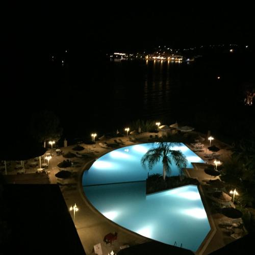 an overhead view of a swimming pool at night at Hotel Golden Sun in Finikounta