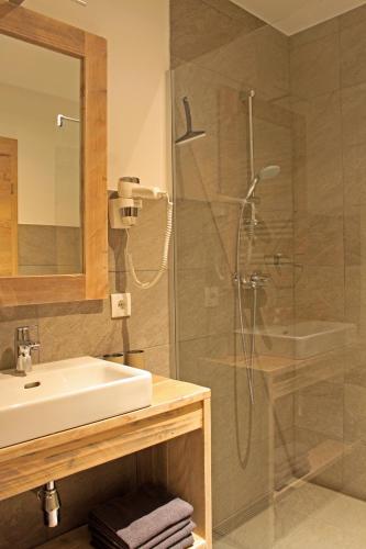 a bathroom with a shower and a sink at Nockberge Lodge in Bad Kleinkirchheim