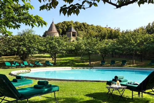 una piscina en un patio con sillas y mesa en Château de Bagnols, en Bagnols