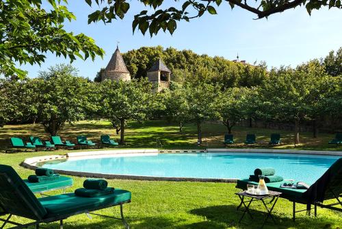 uma piscina num quintal com cadeiras e uma mesa em Château de Bagnols em Bagnols