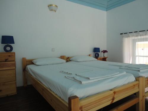 a bedroom with a large bed with white sheets and a window at Halki Townhouse in Halki