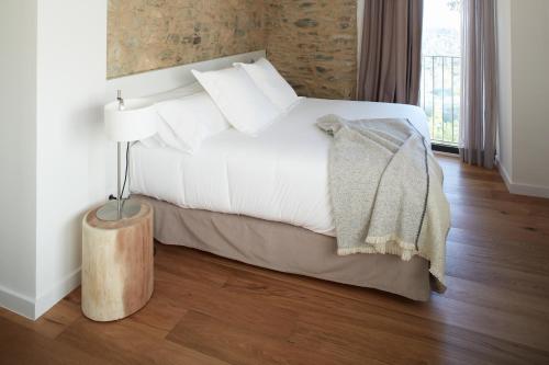 a bedroom with a white bed and a lamp at Mas Vivent in Vilamaniscle