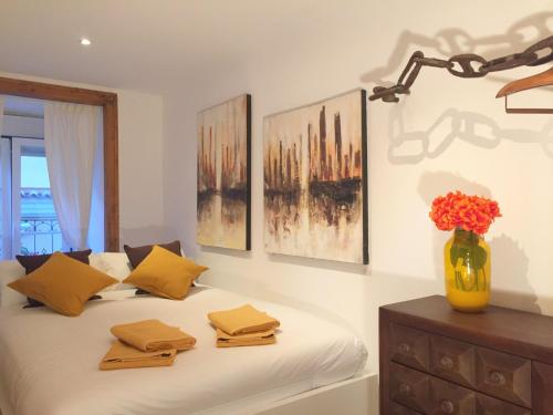 a bedroom with a bed with a vase of flowers on it at BairroSweethome in Lisbon
