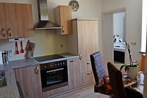 a kitchen with wooden cabinets and a stove at Ferienwohnung Kopp II in Greiz