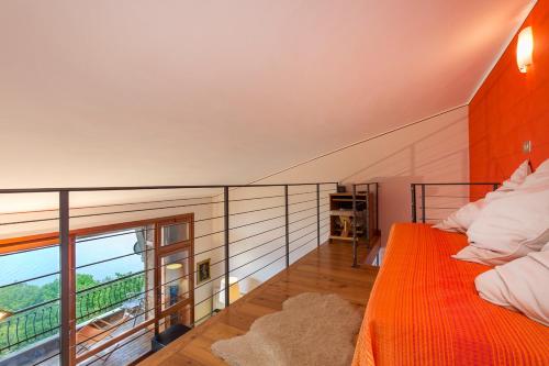 ストレーザにあるApartment Albicoccaのベッドルーム(オレンジ色のベッド1台、バルコニー付)