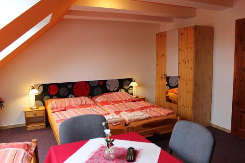 a bedroom with a bed and two chairs and a table at Dj-penzion in Vracov