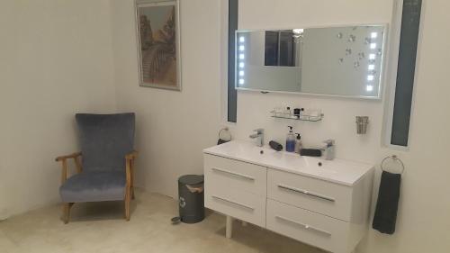 a bathroom with a sink and a chair and a mirror at Atlantic Loft - Open plan apartment with Sea Views in Melkbosstrand