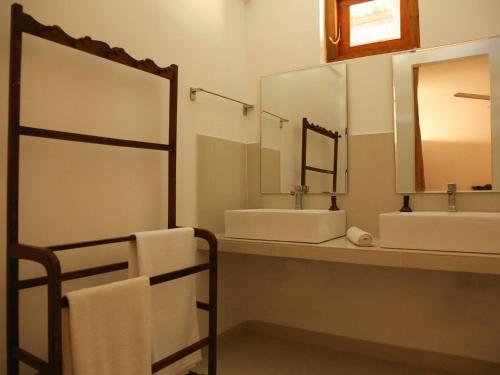Pasikudah Eco Village Hotel في باسيكودا: حمام به مغسلتين ومرآة كبيرة