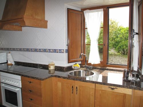 a kitchen with a sink and a window at Apartamentos Casa Cerolleiro in Castropol
