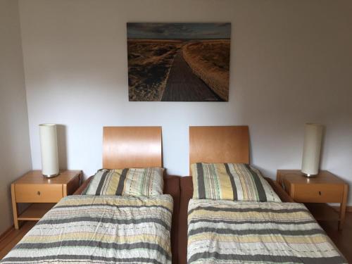 ボルクムにあるAusternfischer Fewo Iのベッド2台が隣同士に設置された部屋です。