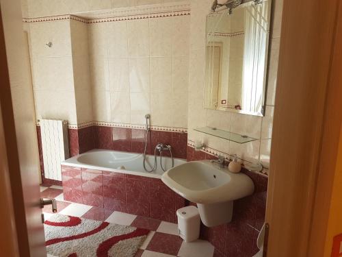 uma casa de banho com uma banheira, um lavatório e um espelho. em Thousand Colors em Nápoles