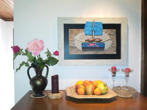 トリャブナにあるArt - M Galleryの壁に飾られた絵と果物を添えたテーブル