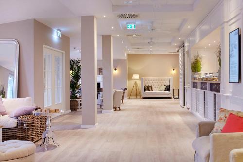 a living room with couches and a salon at Beach Motel Heiligenhafen in Heiligenhafen