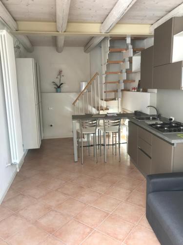 eine Küche und ein Esszimmer mit einem Tisch und Stühlen in der Unterkunft Antonella Gardalake 2 in Desenzano del Garda